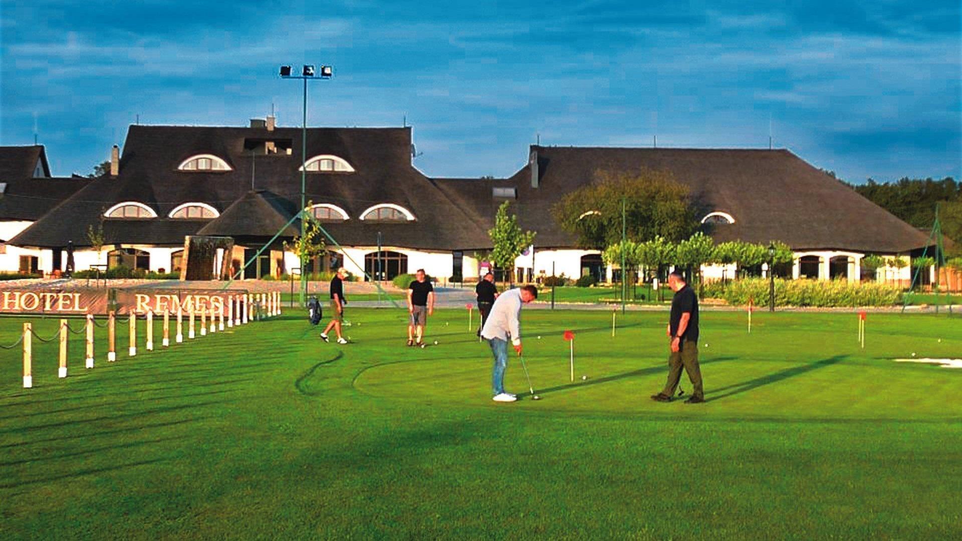 Hotel z polem golfowym i widokiem na budynki w tle.