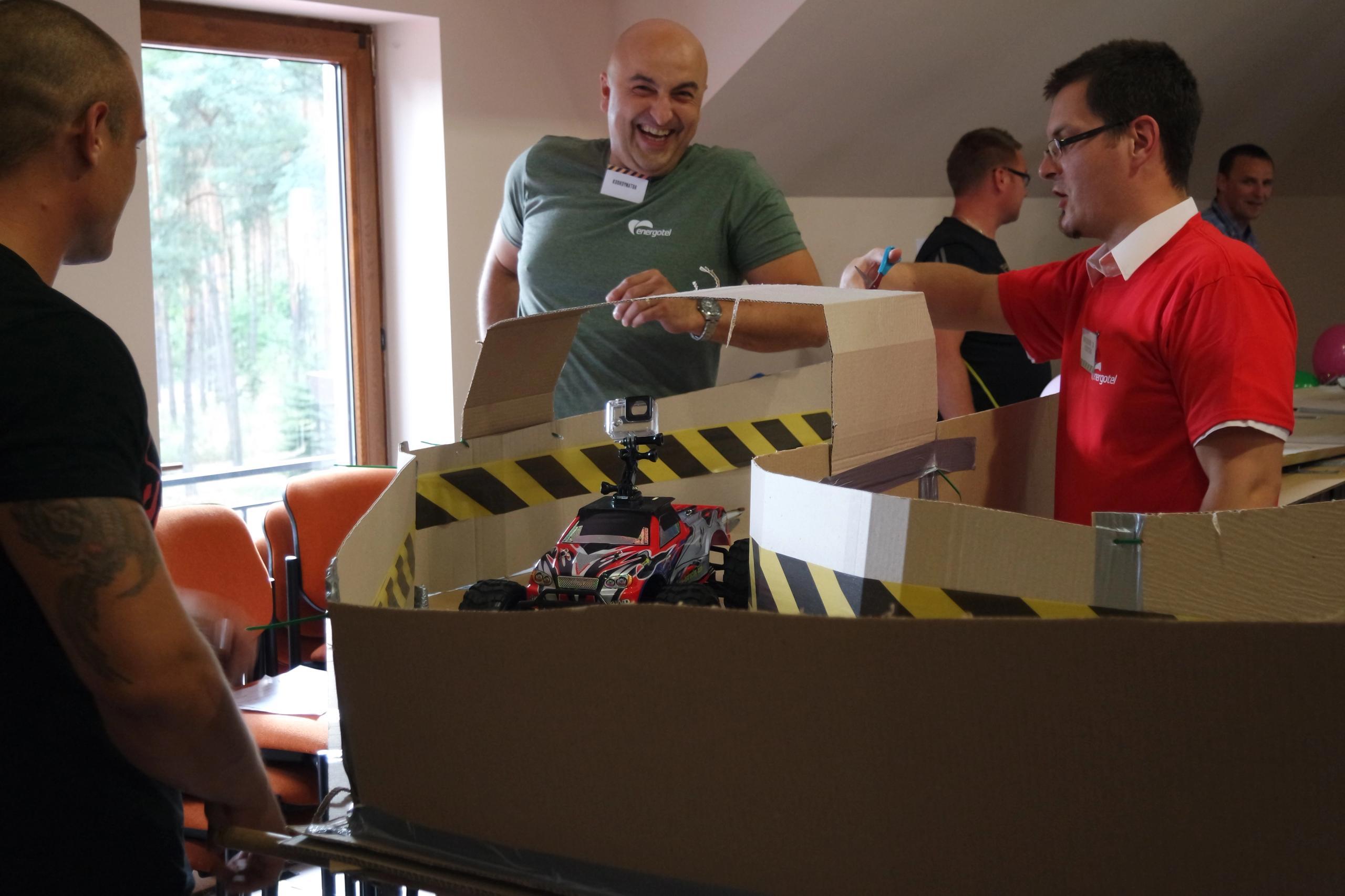 Zespół pracowników rozpakowujący materiały eventowe – moment przygotowań do aktywności integracyjnej.