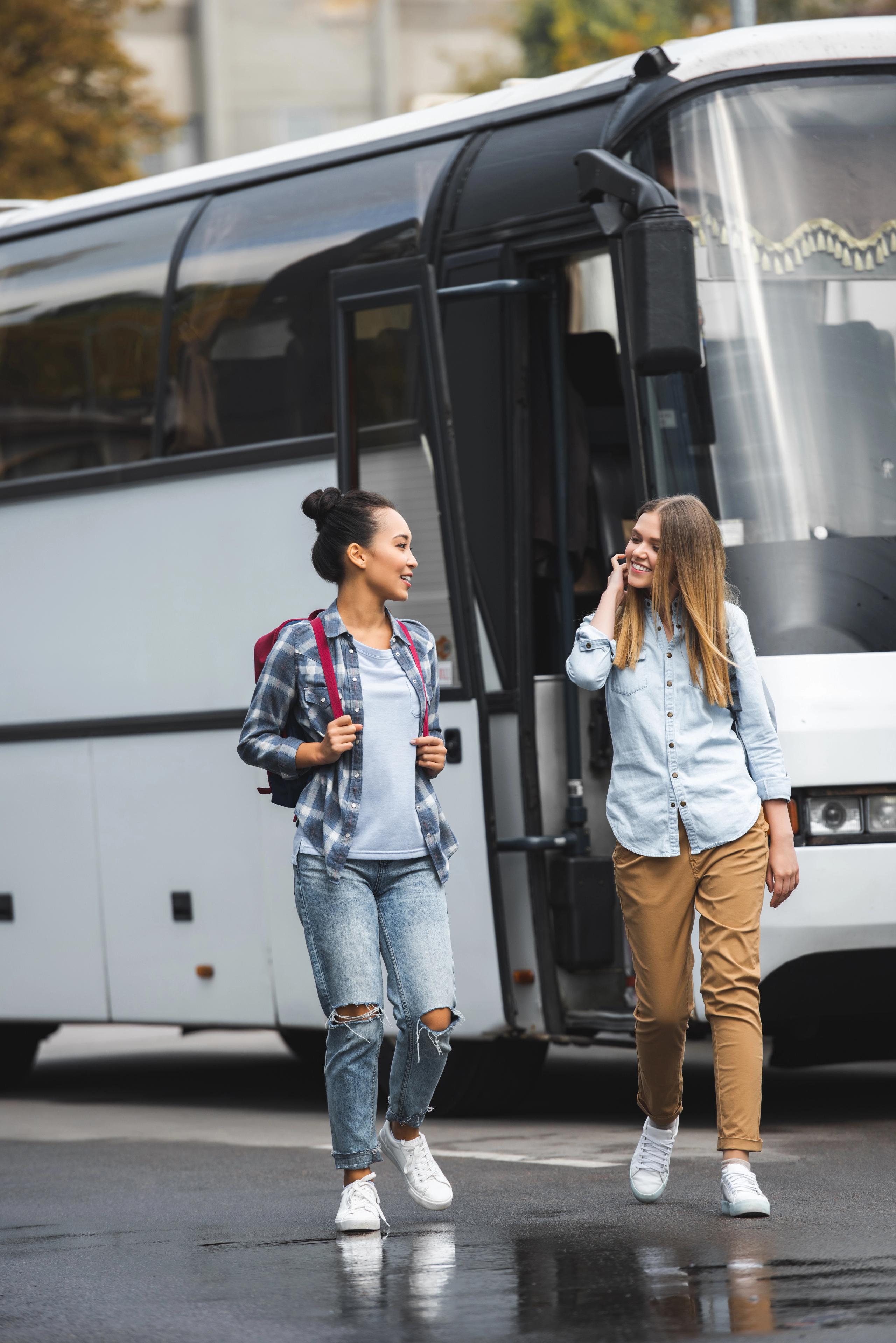 Kobieta z walizką wsiadająca do autobusu turystycznego.