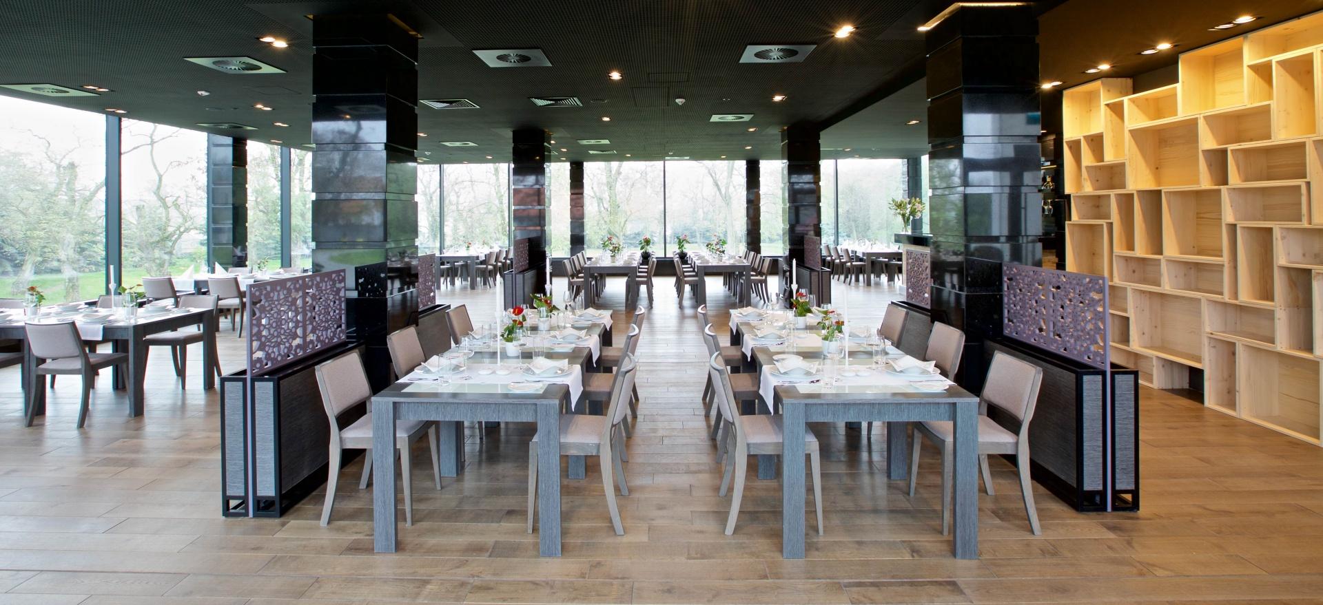 Restauracja hotelowa z panoramicznymi oknami i nowoczesnym wystrojem.