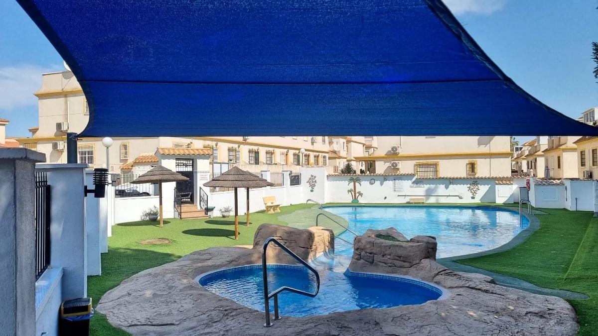 Large blue shade sail installed above a communal swimming pool area