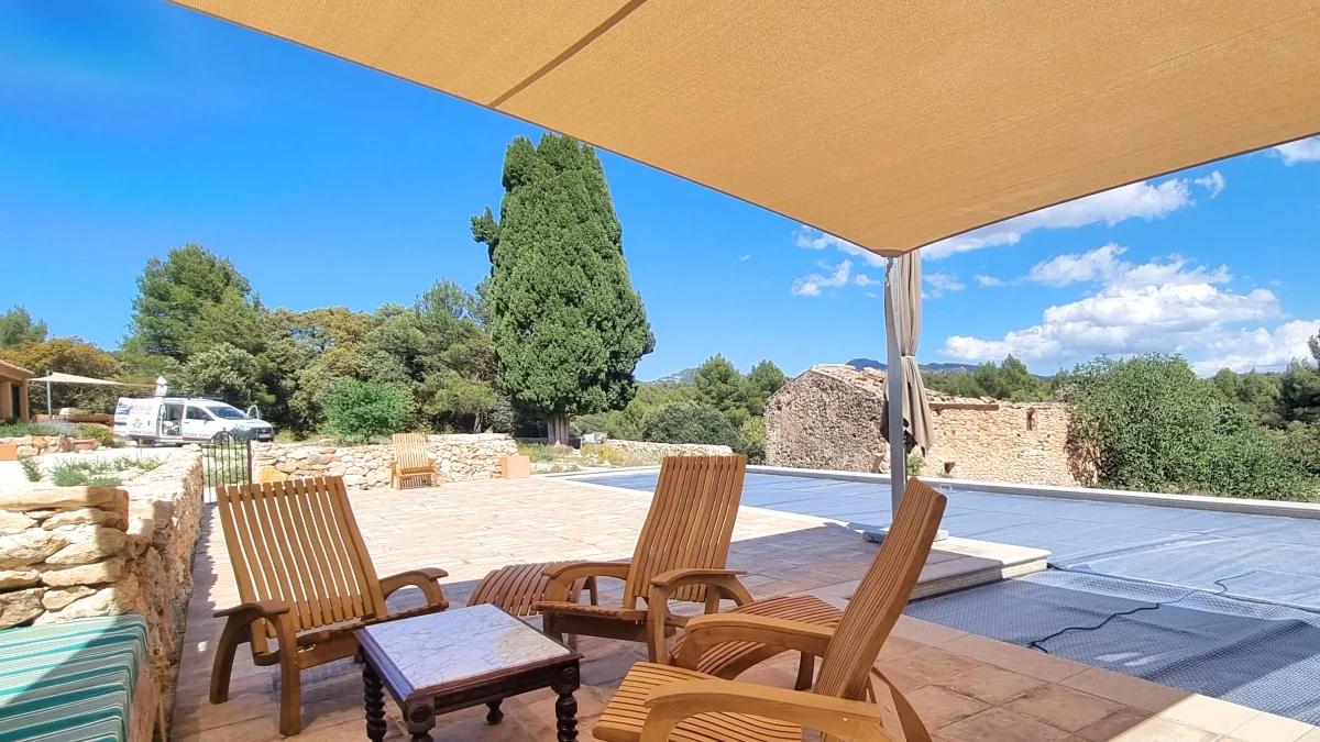 Maatwerk schaduwdoek dat schaduw geeft over een terras naast een zwembad