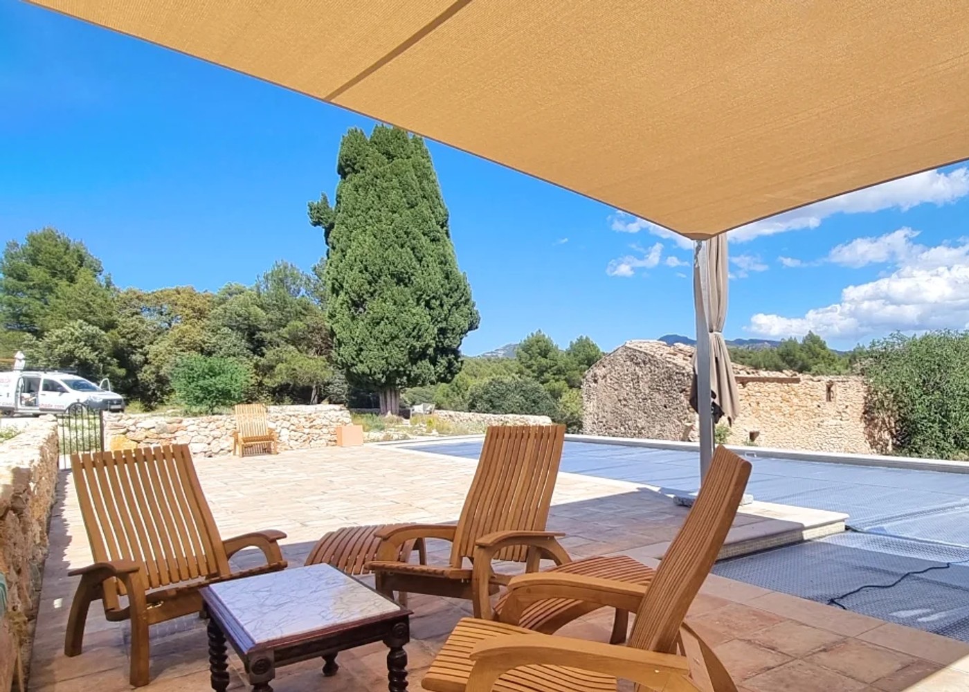 Maatwerk schaduwdoek dat schaduw geeft over een terras naast een zwembad