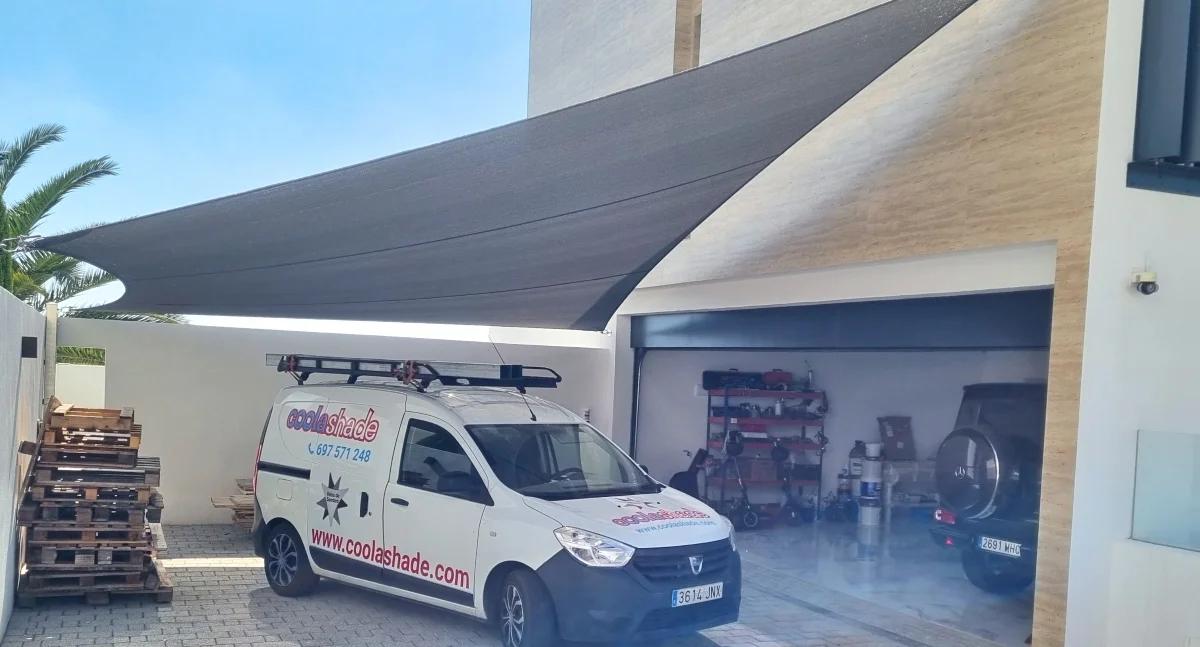 Modern schaduwdoek geïnstalleerd boven een carport bij een woning door Coolashade