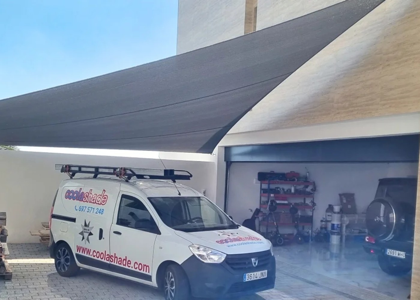 Modern schaduwdoek geïnstalleerd boven een carport bij een woning door Coolashade