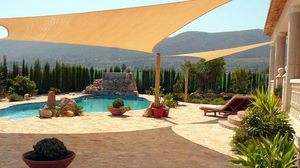 Large shade sails installed above a luxury pool terrace with mountain views
