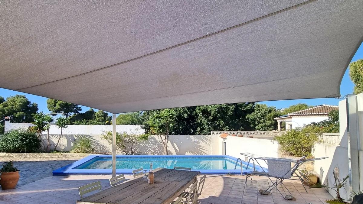 Groot schaduwdoek dat schaduw geeft boven een zwembadterras in Moraira