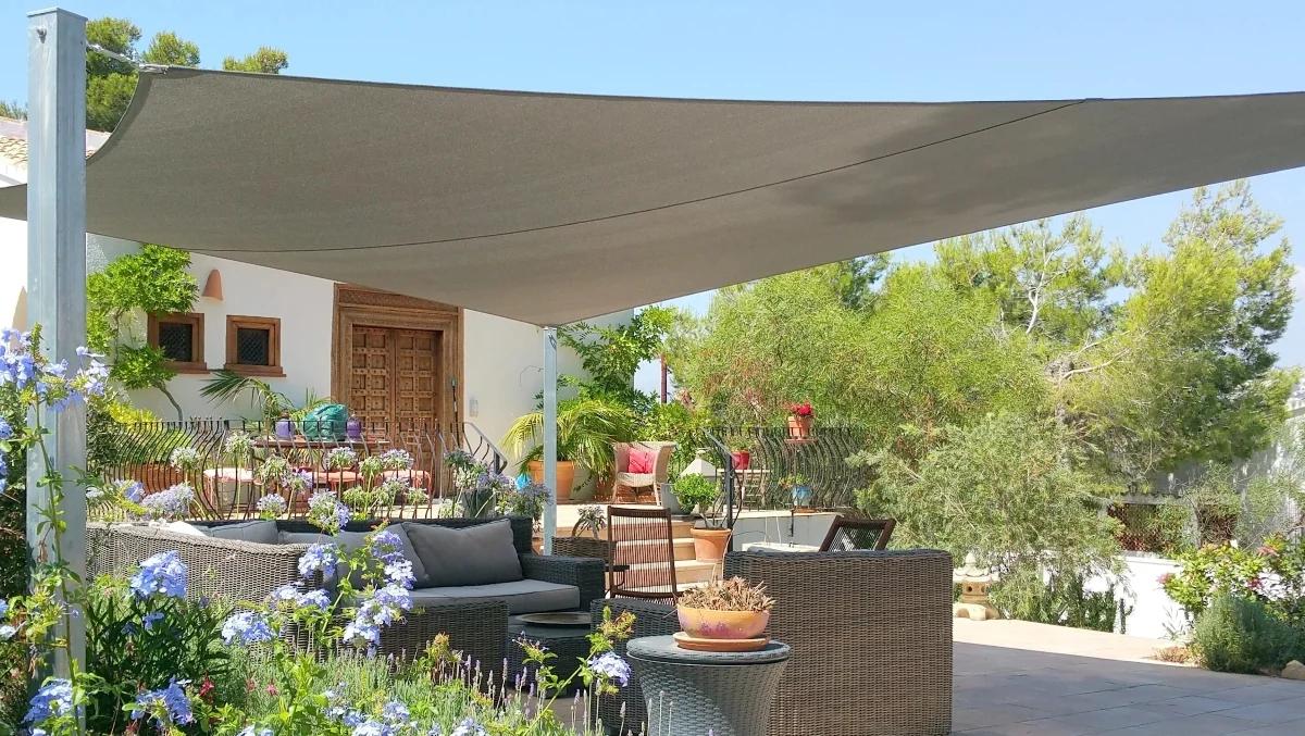 Stylish shade sail covering a garden terrace lounge area