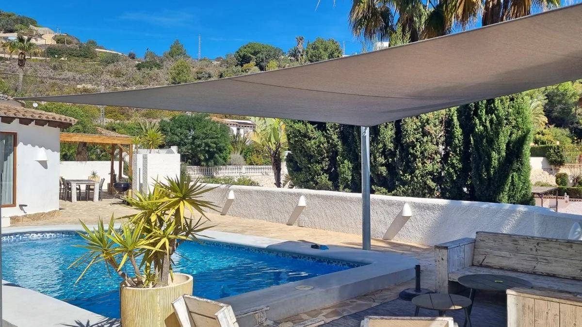 Tensioned shade sail above a swimming pool terrace on the Costa Blanca