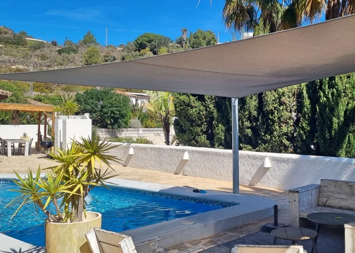Tensioned shade sail above a swimming pool terrace on the Costa Blanca