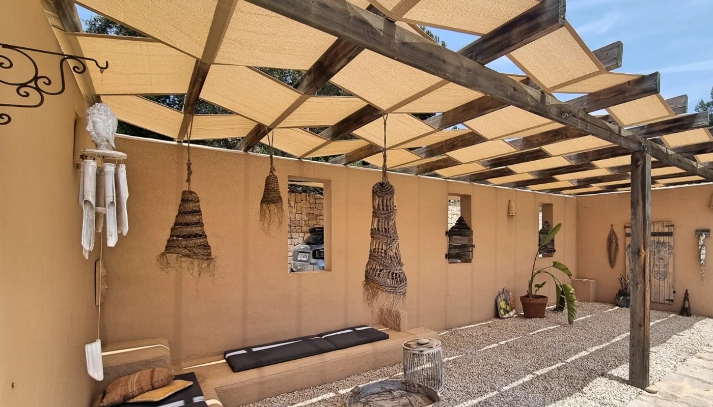 Shade sail installation integrated into a wooden pergola structure for filtered sun protection