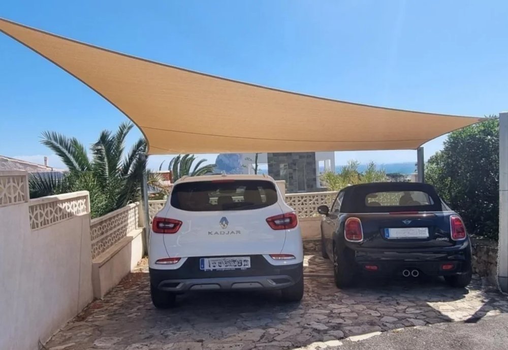 Custom triangular shade sail installed over residential carport on the Costa Blanca