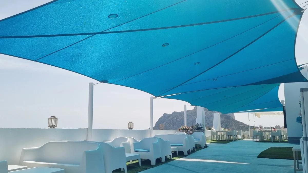 Large blue shade sail installation above a beachfront terrace on the Costa Blanca