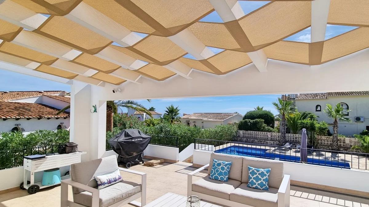 Pergola roof with woven shade panels above a terrace seating area