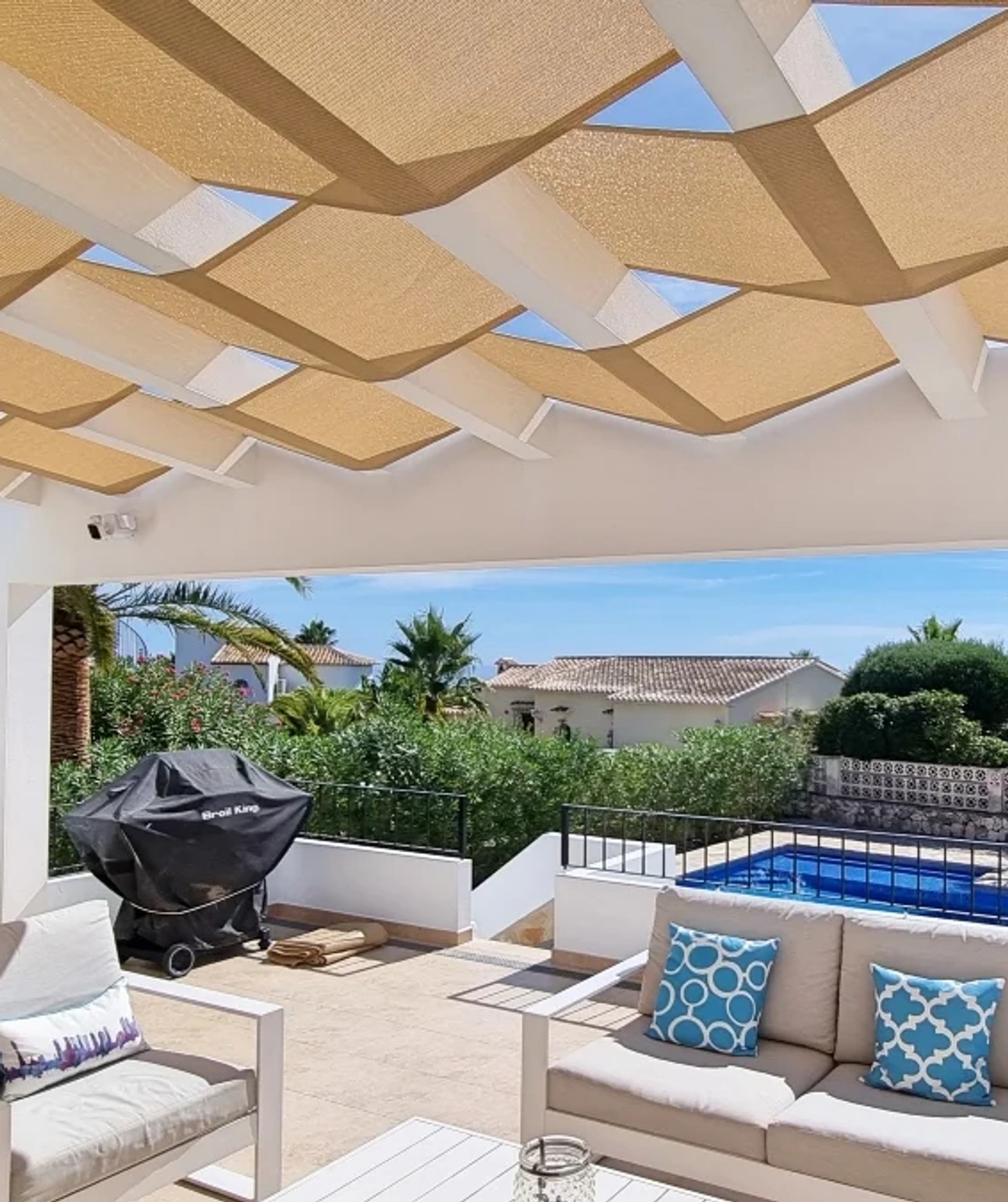 Pergola roof with woven shade panels above a terrace seating area
