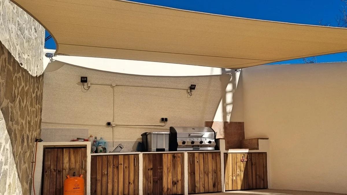 Schaduwdoek geïnstalleerd boven een buitenkeuken op een terras aan de Costa Blanca
