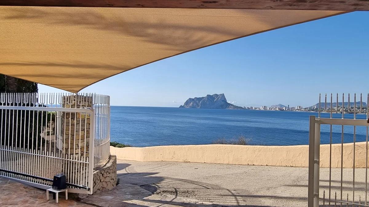 Shade sail over a terrace with sea views and the Penon de Ifach in the distance