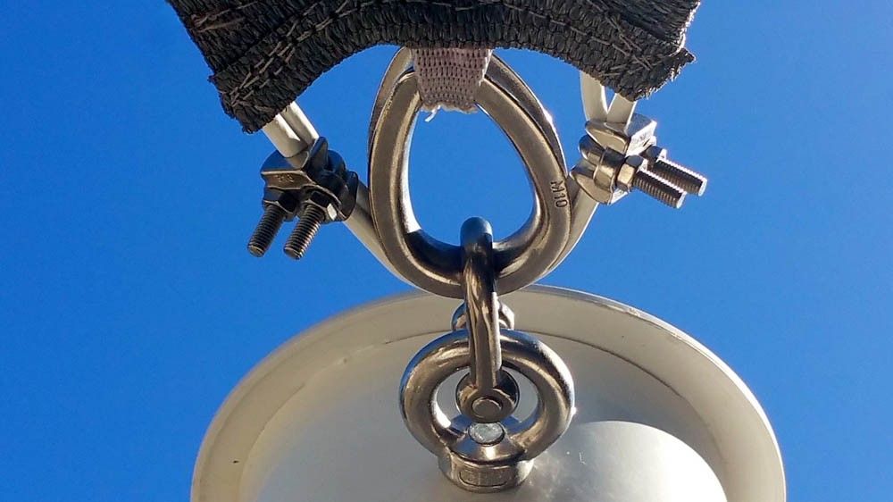 Close-up of stainless steel eye bolt and tension hardware for a shade sail