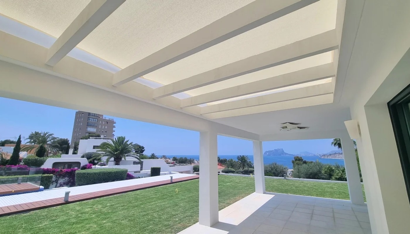 Modern white pergola structure with integrated shade sail system