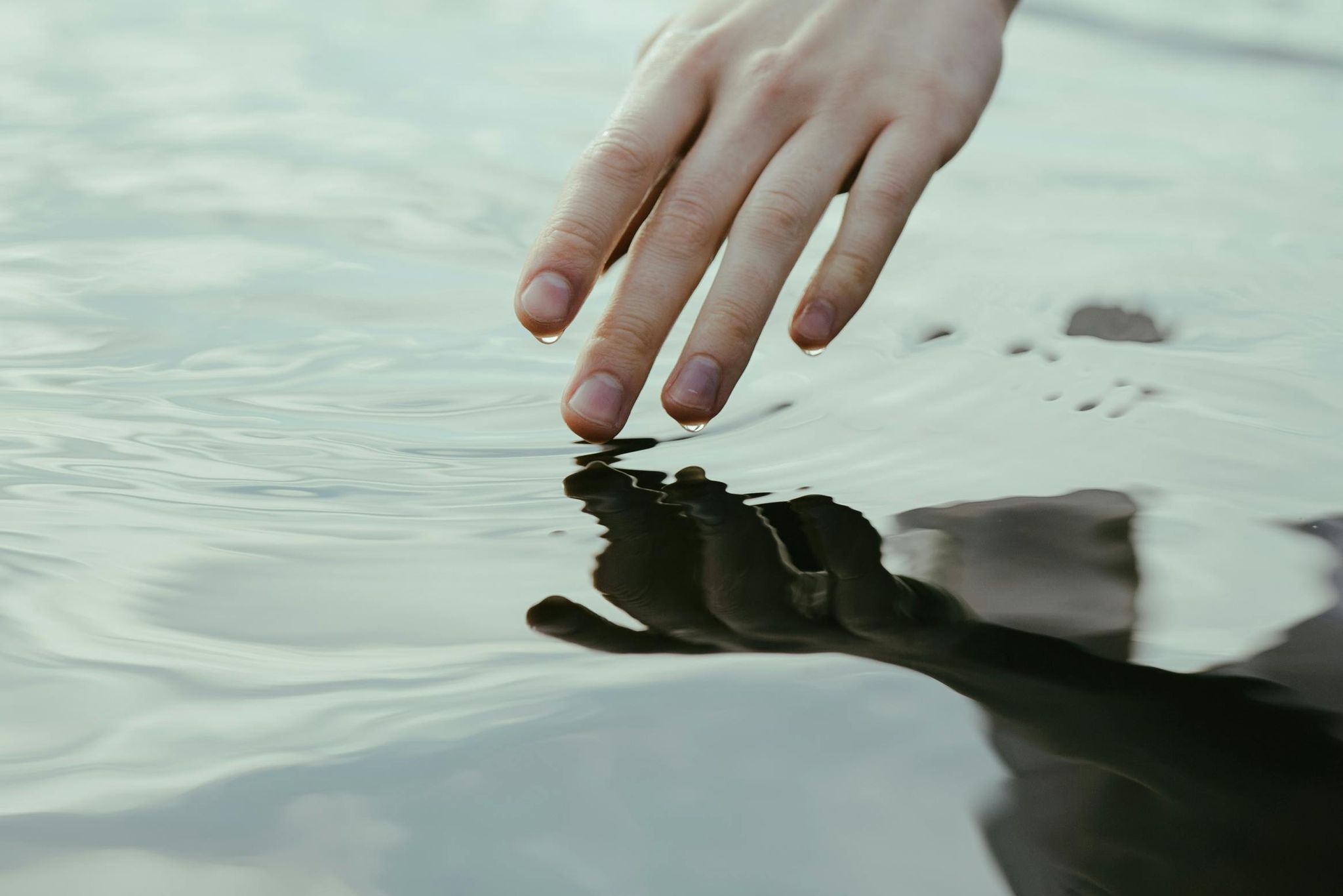 Artistic hand in water mirror reflection.