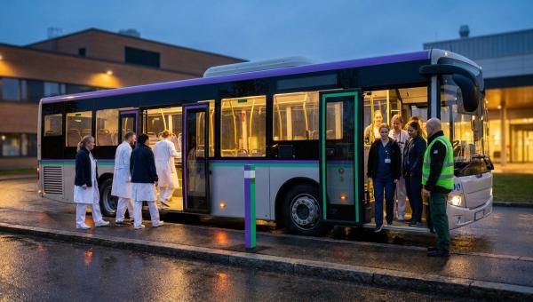 Службовий автобус біля входу в лікарню в сутінках: одна зміна медпрацівників виходить, інша заходить у салон.