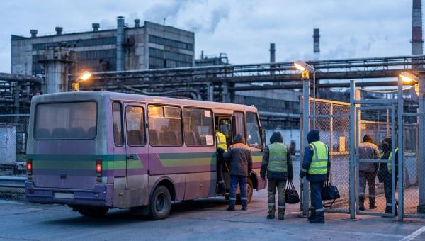 Заводський мікроавтобус забирає нічну зміну біля прохідної підприємства у промзоні вдосвіта