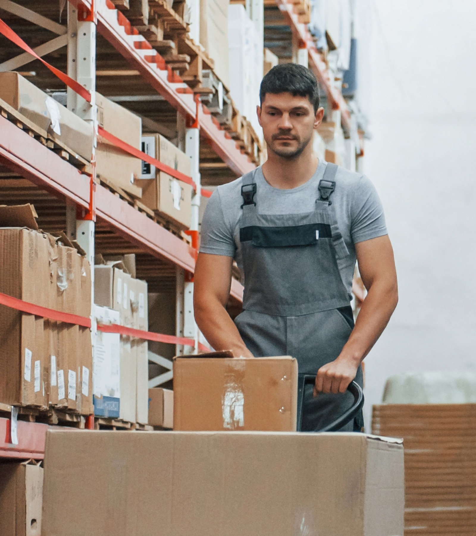 Warehouse worker moving boxes through a storage aisle