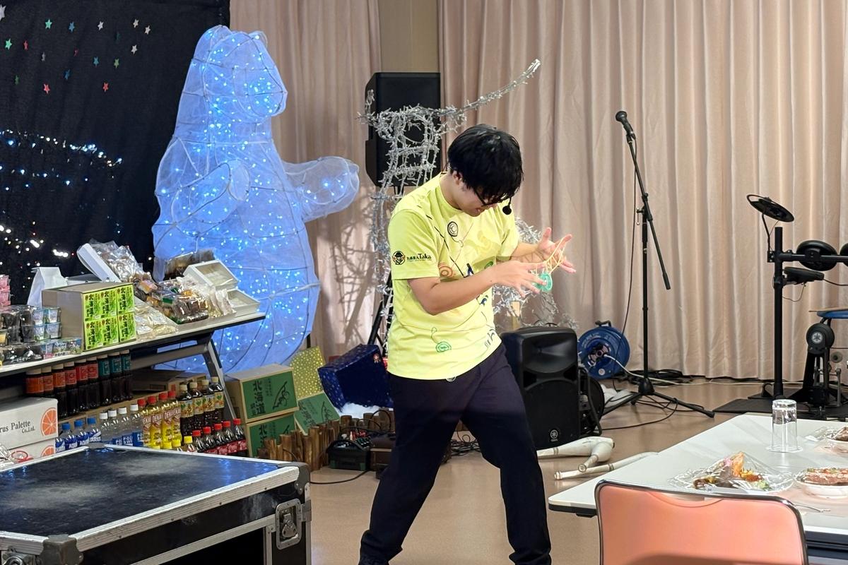 あやとりのように紐をあやつり、ヨーヨーをのせるTaka