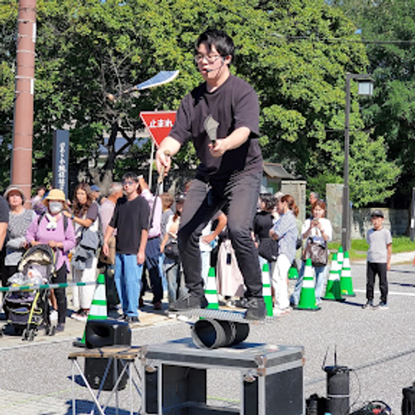 ローラーの上でバランスを取りながらジャグリングを行う千里の写真