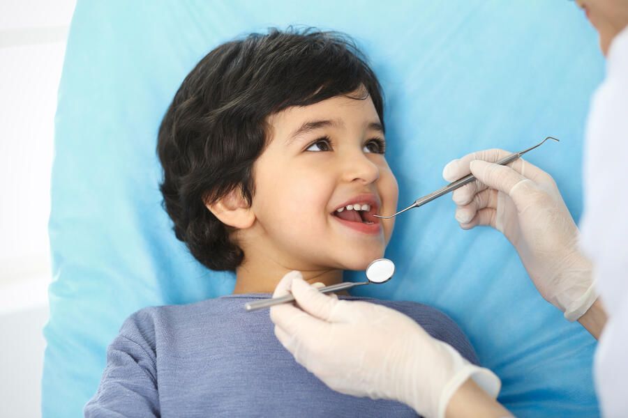 Cute little boy at the dentist's office is going to receive dental sealants