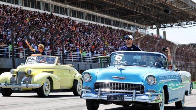 Nicky and Alex soak up the sun in these classic cars for the pre-race drivers’ parade.