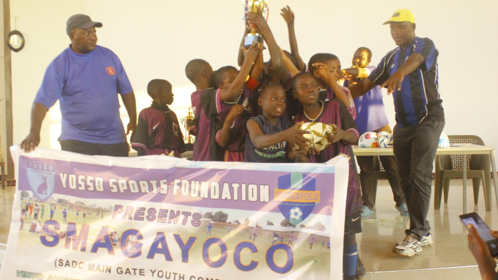 YFC U11 players celebrating together while lifting the SMAGAYOCO Tournament trophy.