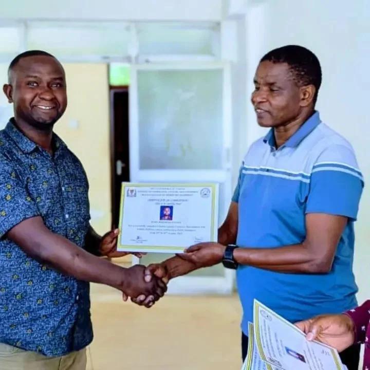 Course participants holding certificates after completing sports management training.