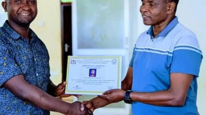Course participants holding certificates after completing sports management training.