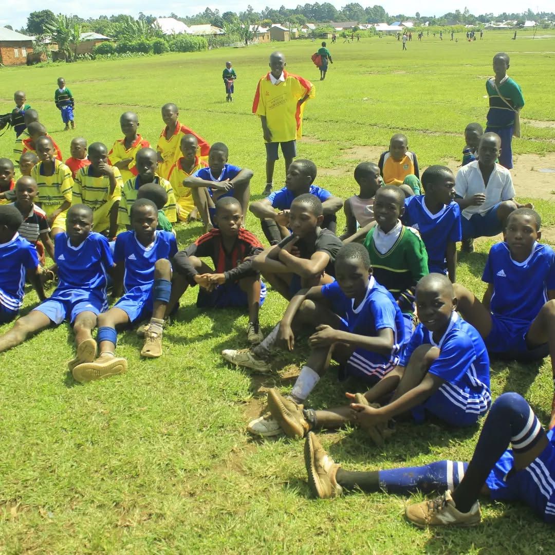 Young players in blue and yellow kits resting on the grass