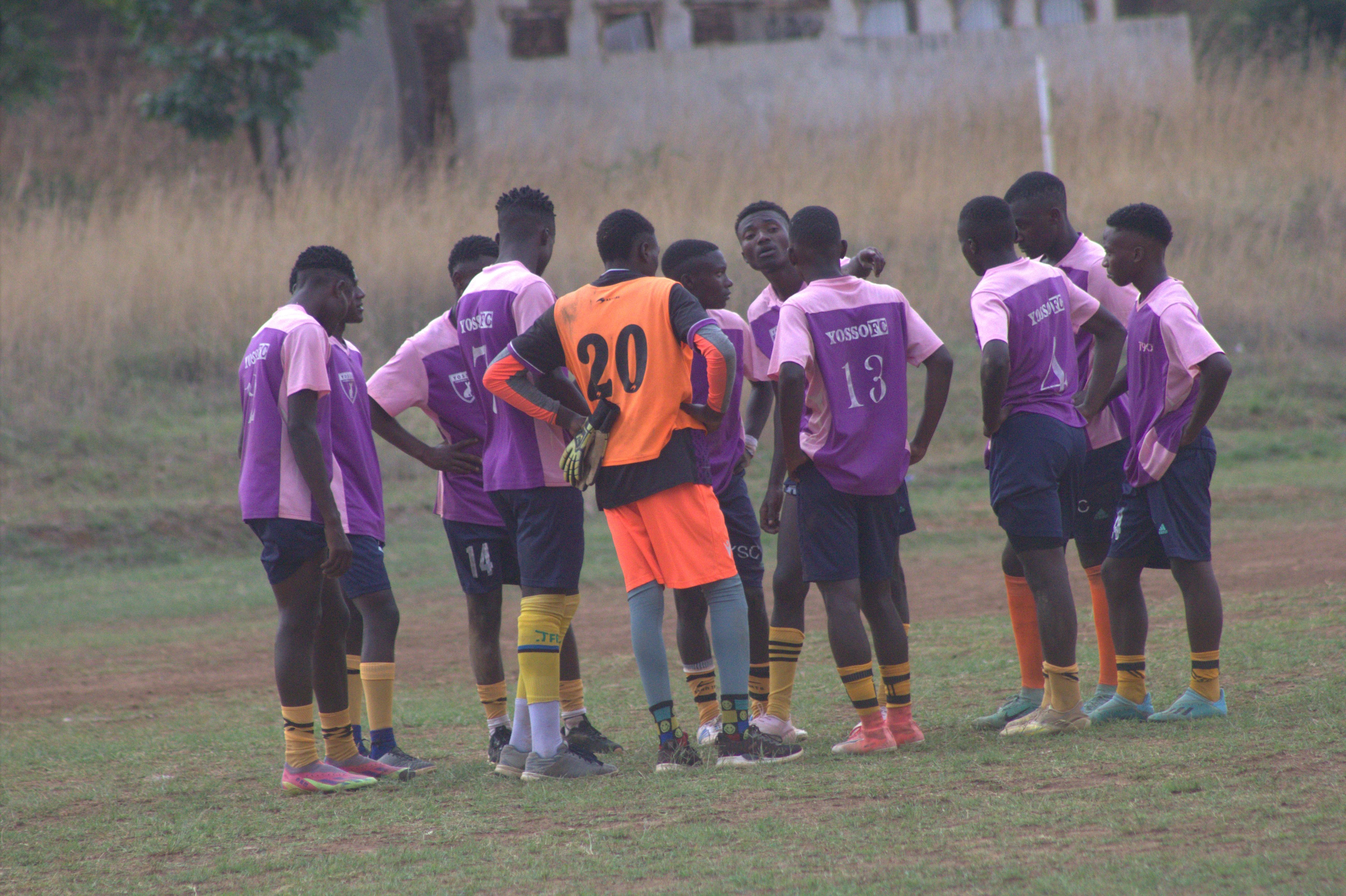 Yosso FC players and goalkeeper huddled for pre-match instructions