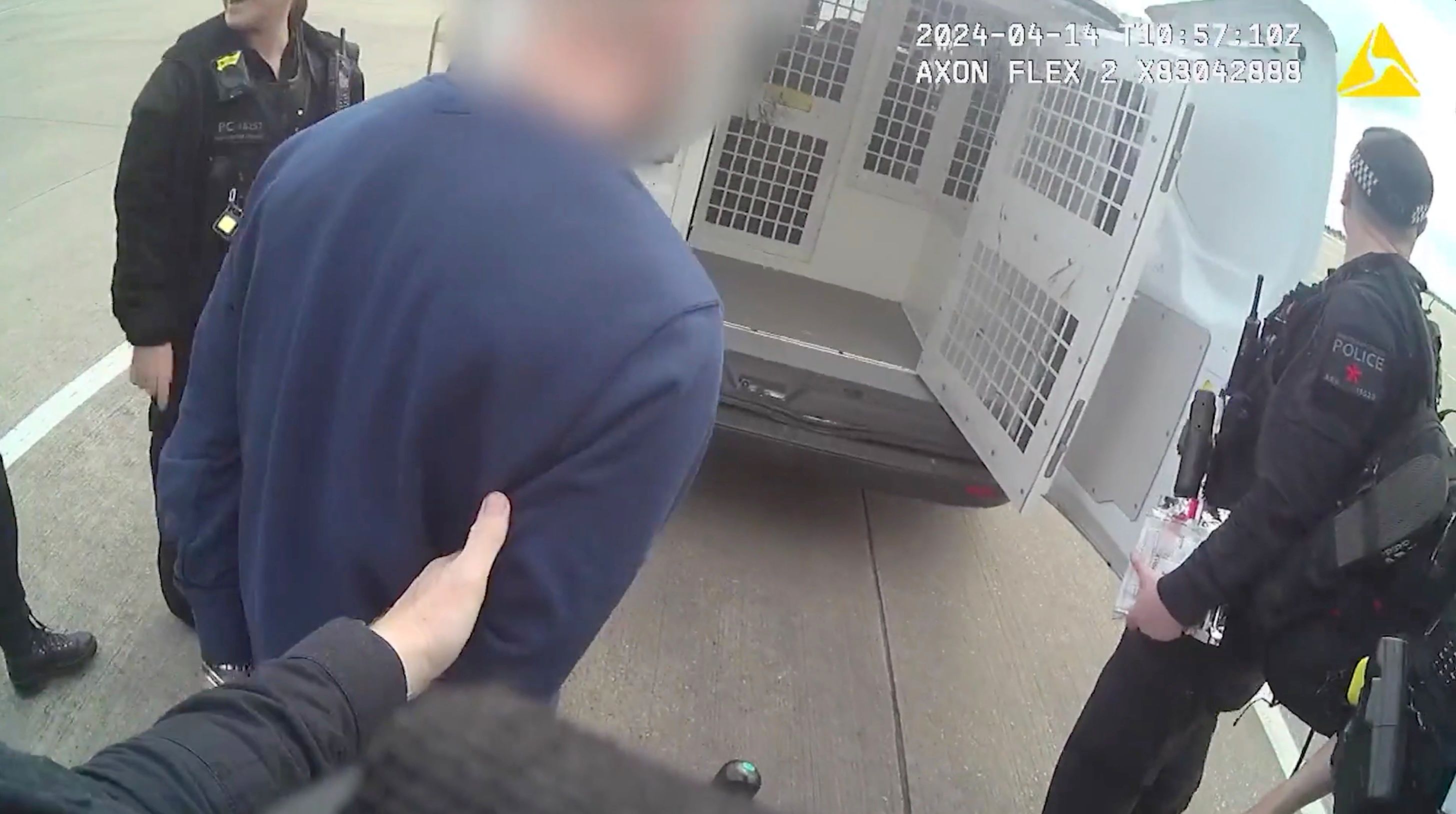 Zak Coyne is escorted to a police van at Manchester Airport after being arrested on April 14, 2024. (Source: U.K. Metropolitan Police)