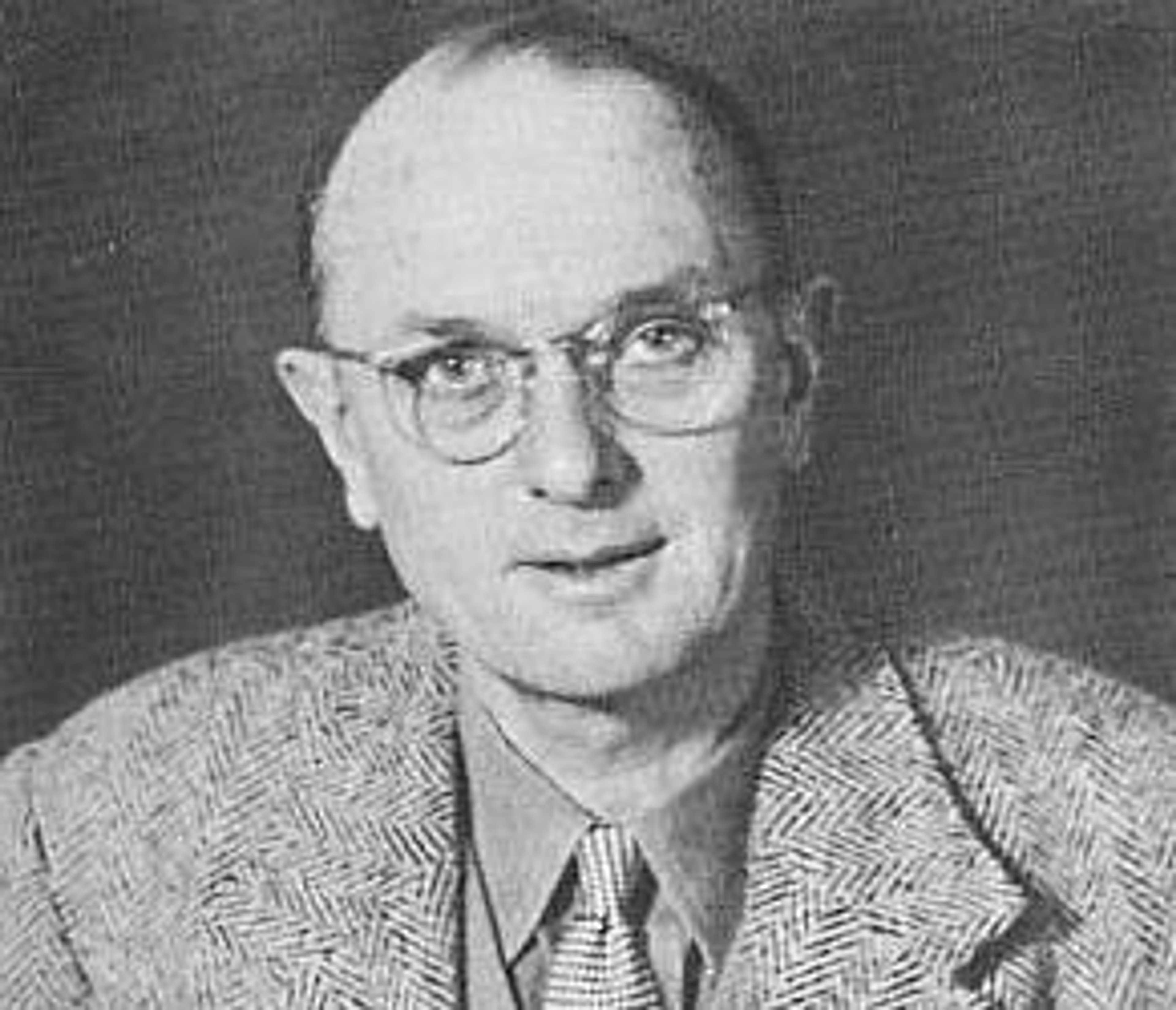 Black and white photographic portrait of Christopher Clayton 'Clutty' Hutton, and older white man wearing glasses and a tweed blazer.