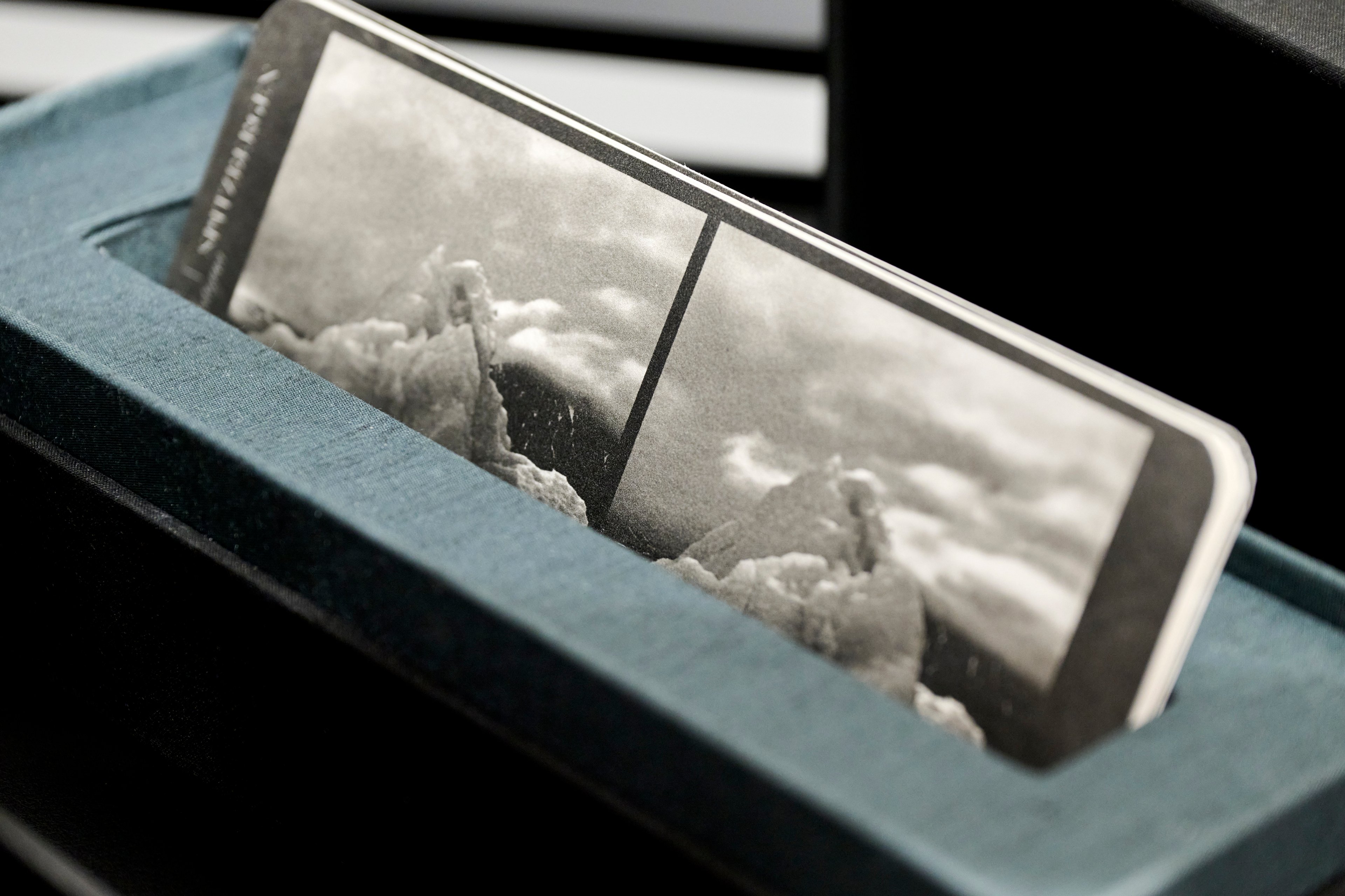 Close up image showing one of Kristina Chan's stereoscope card artworks from "View Finding" in a display box lined with blue materials. The card shows two black and white photographic images of ice formations.