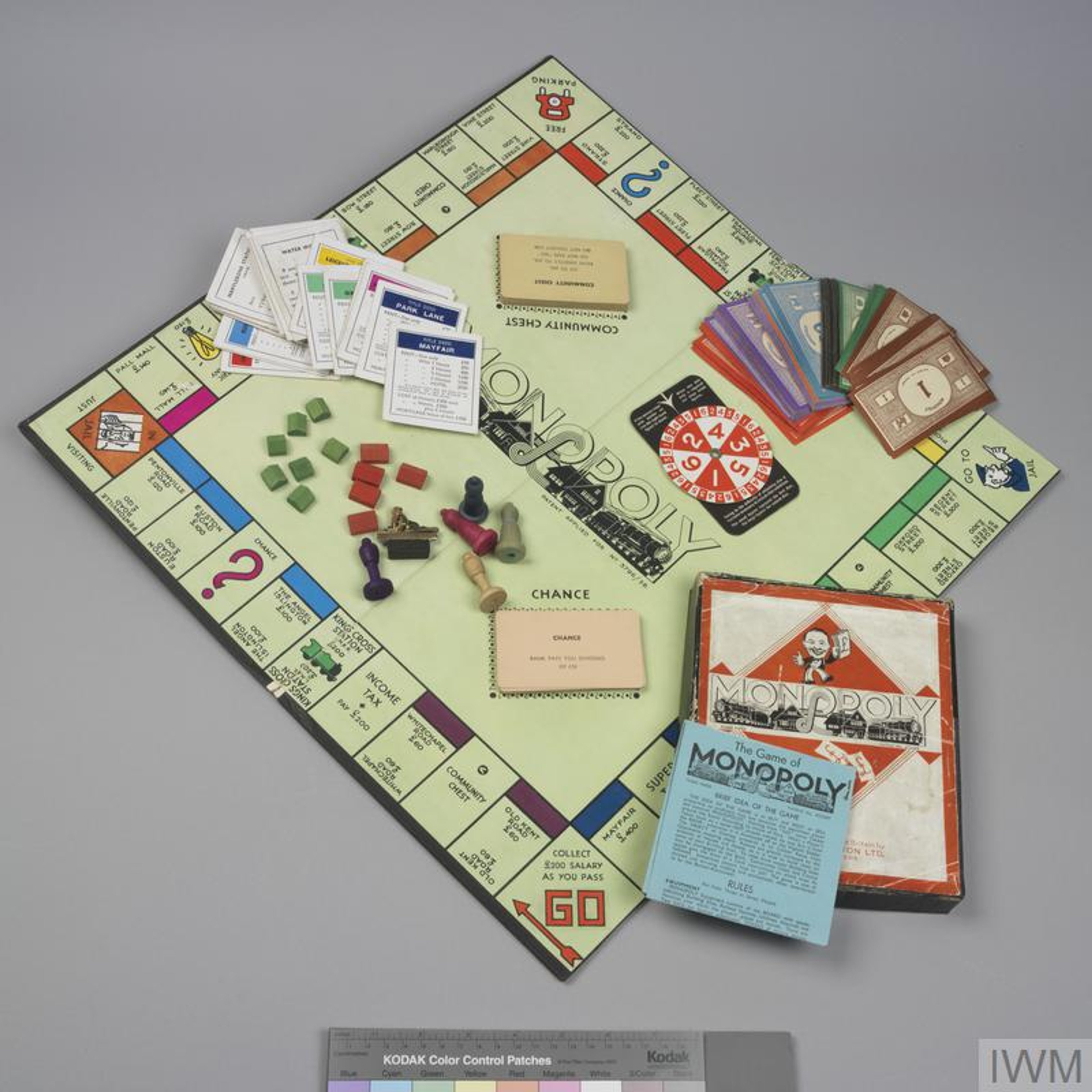 Boxed game of Monopoly laid out with board, playing tokens, accessories and instructions.
