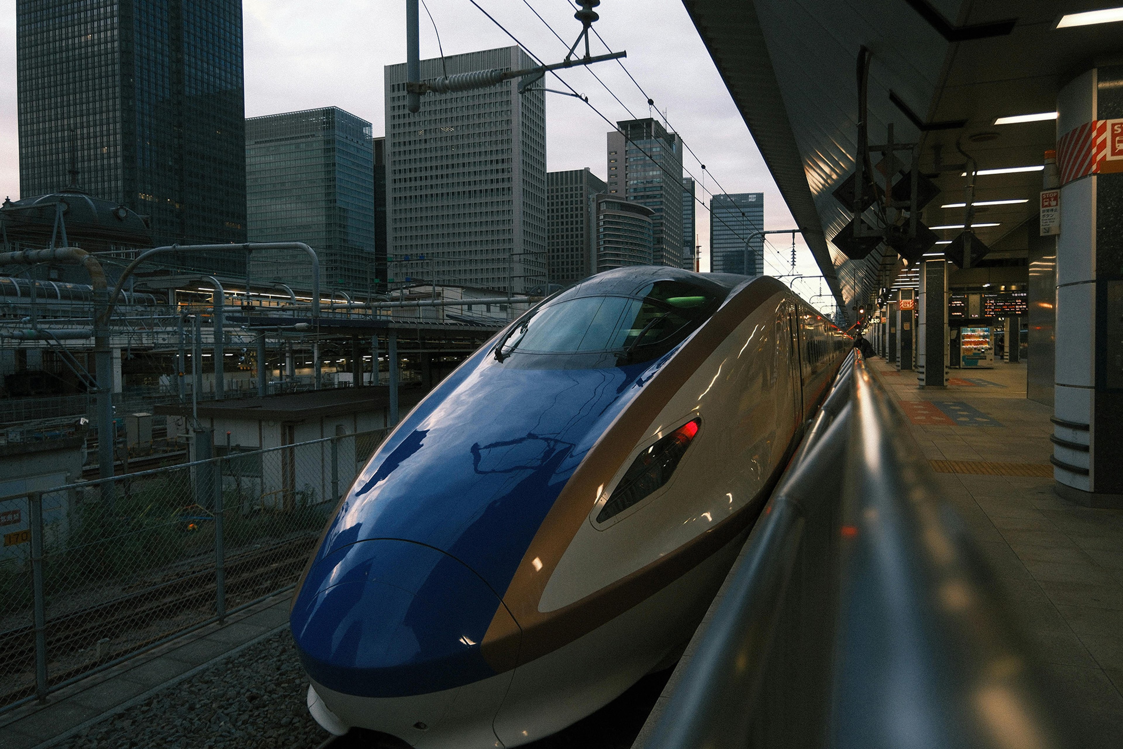 Photograph of the front of a bullet train on the platform at a Tokyo Train Station.