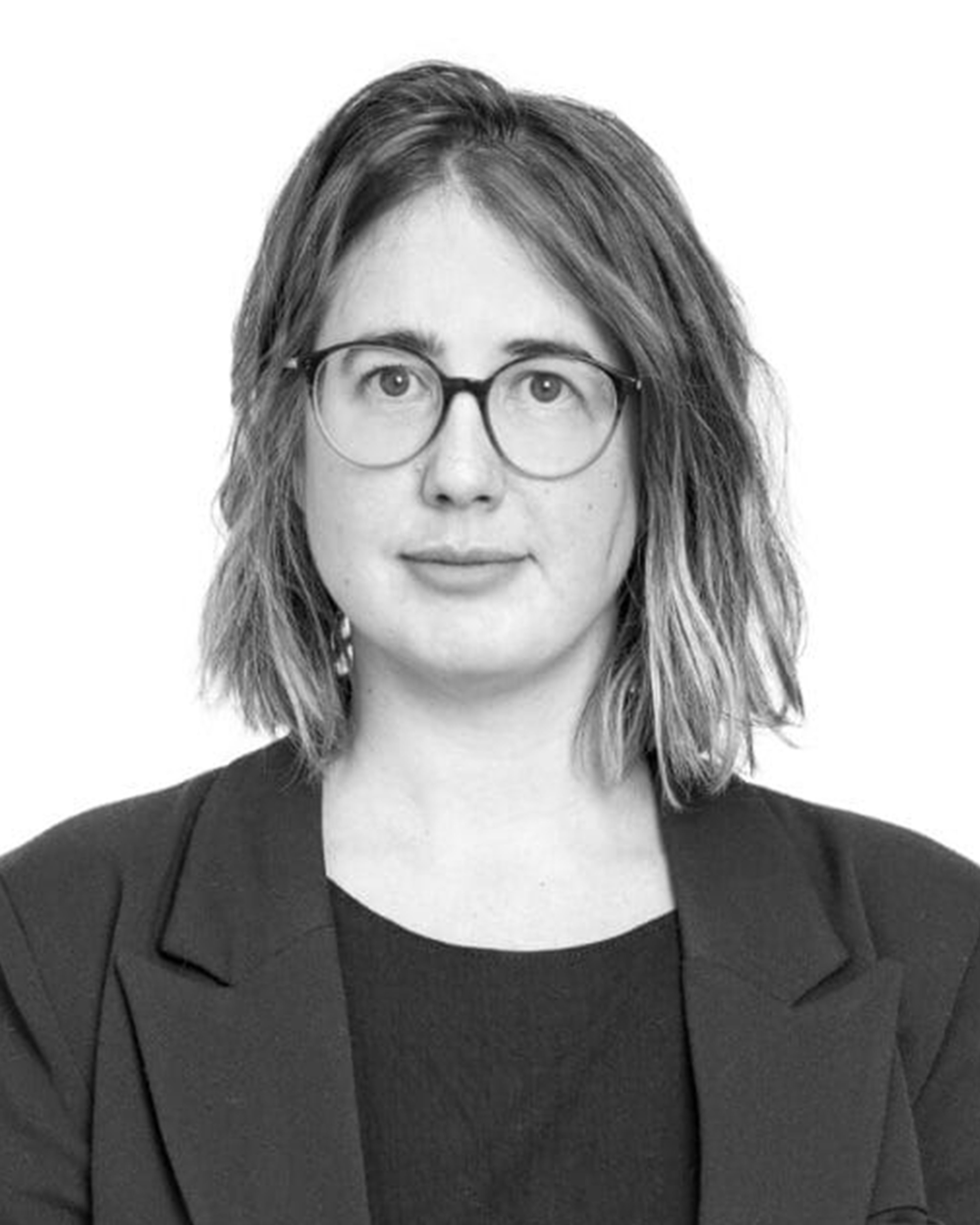Black and white portrait of Dr Sara Öberg Strådal - a white woman with mid length hair and glasses. she is against a white background and wears a smart blazer.