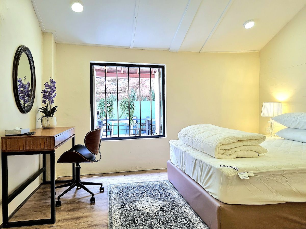 Stewart Hotel compact queen-style room with desk and window