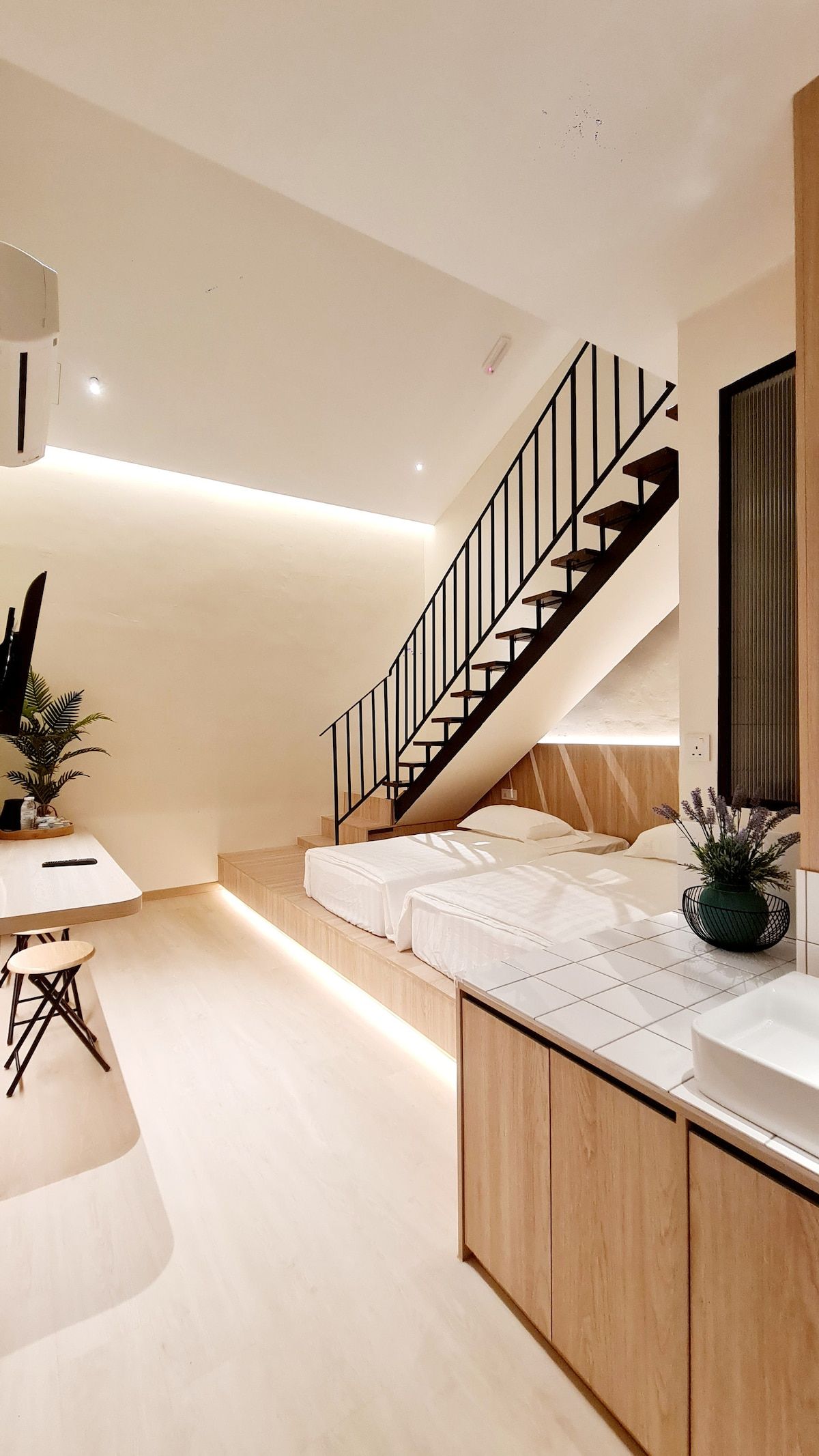 Kazuki duplex room lower level with staircase, twin beds, and vanity