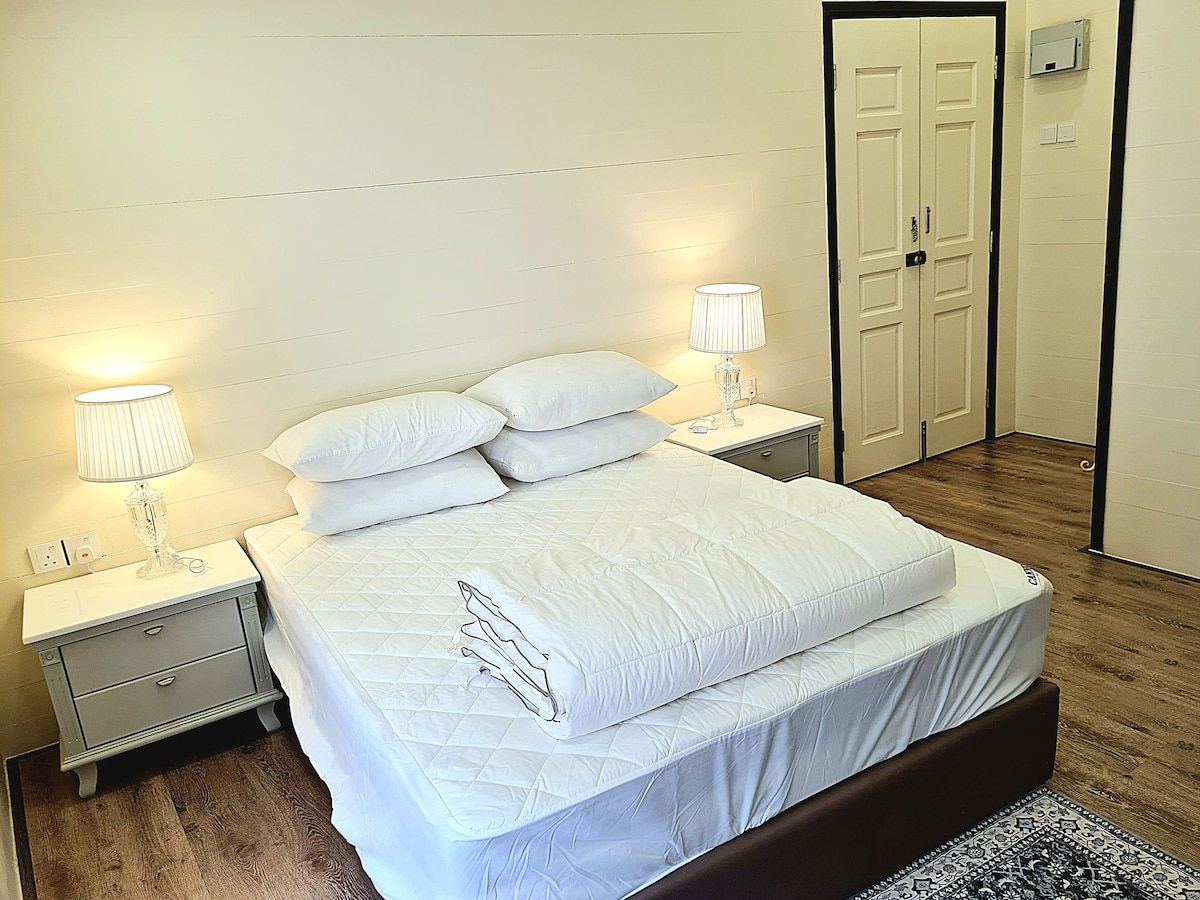 Stewart Hotel compact queen-style room with white linens