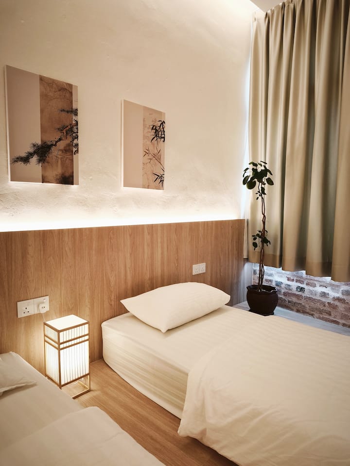 Kazuki twin room with heritage brick wall, curtains, and lantern
