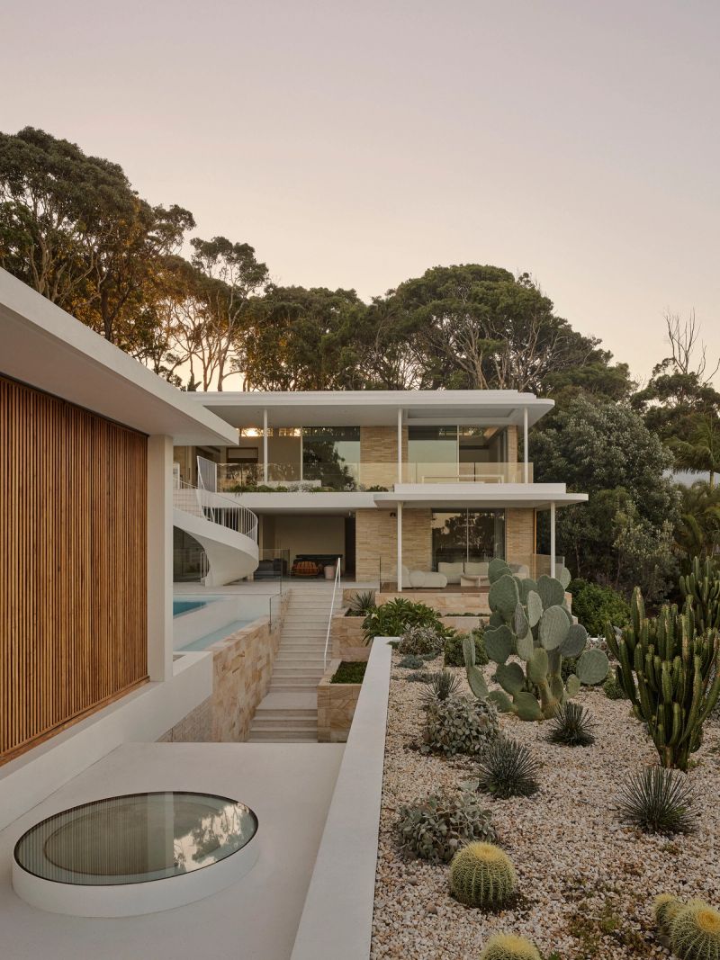 Breeze House at dusk, the two storey pavilion above a cactus garden and the pool