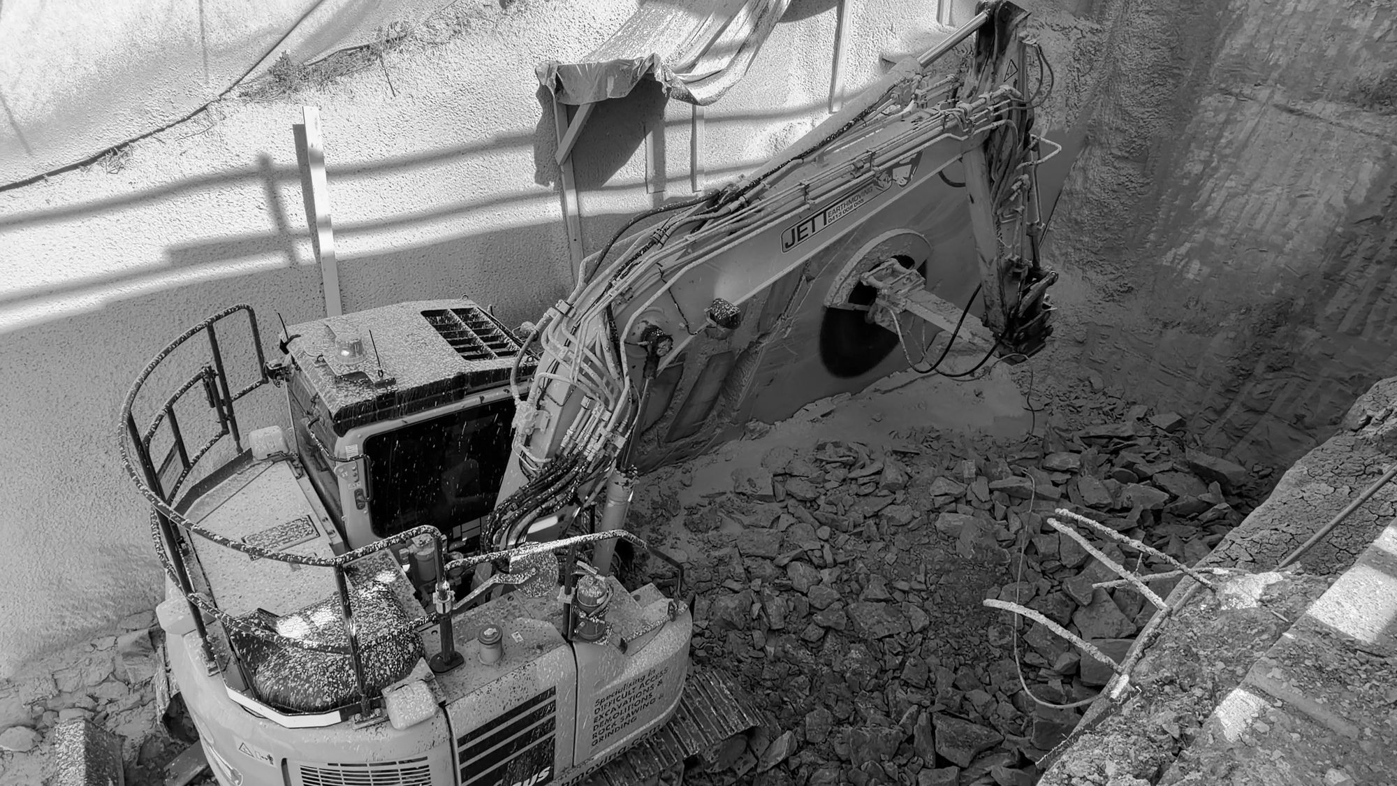 Excavator breaking rock in the basement excavation at Kiora