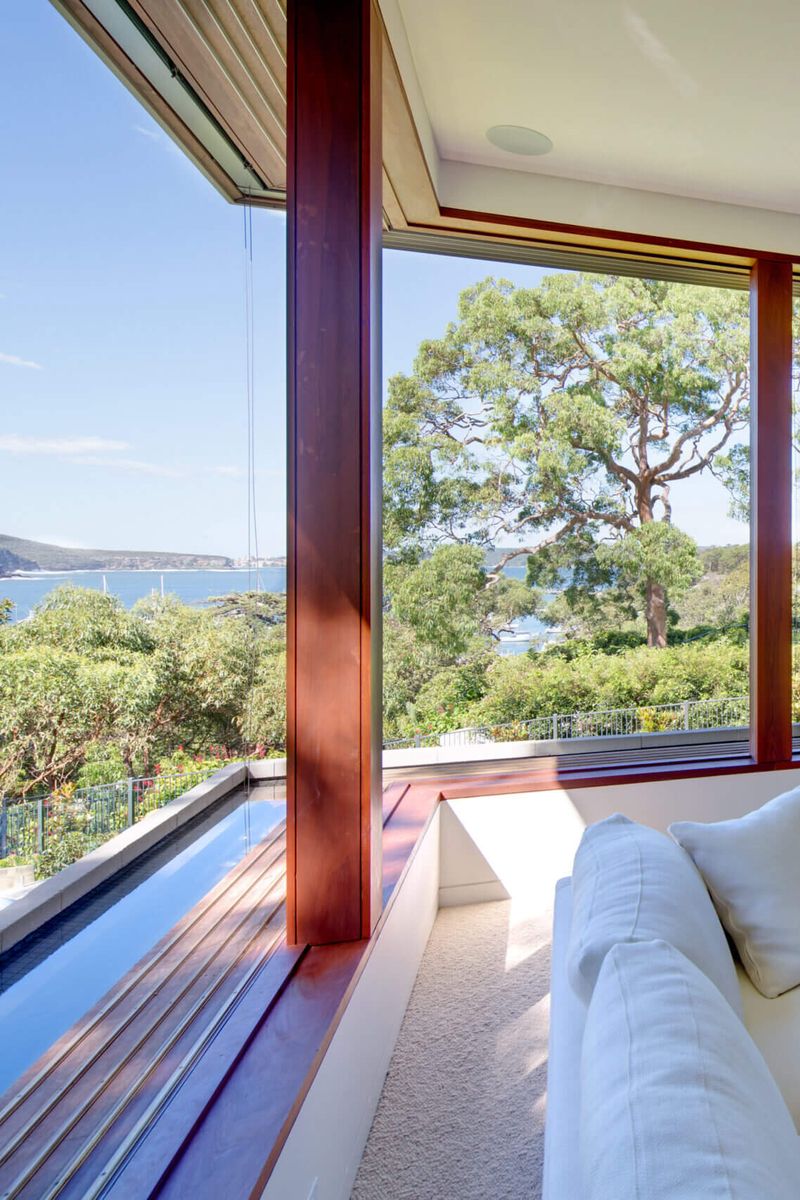 Timber framed window seat and pool edge at Quiet House with a view to the water