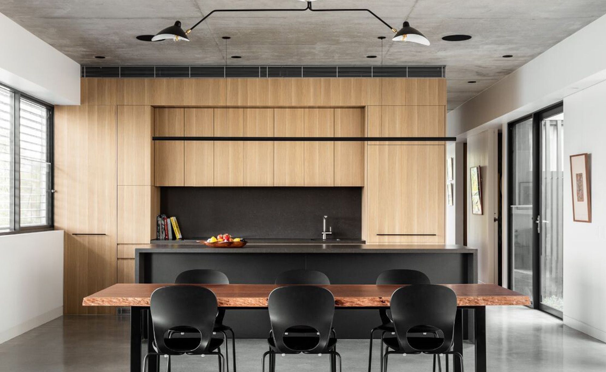 Timber kitchen with a dark island and a long dining table